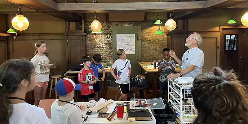 3rd – 5th grade campers listen as preservationist Doug Freerksen explains the craftmanship used to create the Drafting Room’s chains.